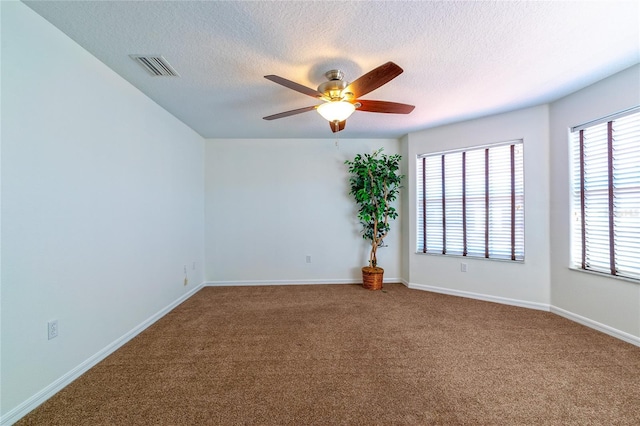 empty room with carpet, ceiling fan, and a textured ceiling