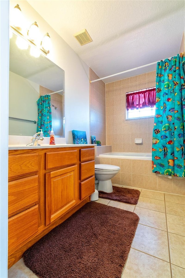 full bathroom with tile patterned floors, shower / tub combo with curtain, vanity, and a textured ceiling