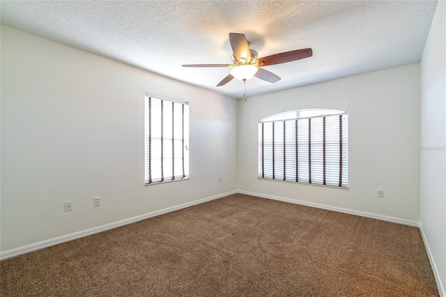 carpeted empty room with ceiling fan and a textured ceiling