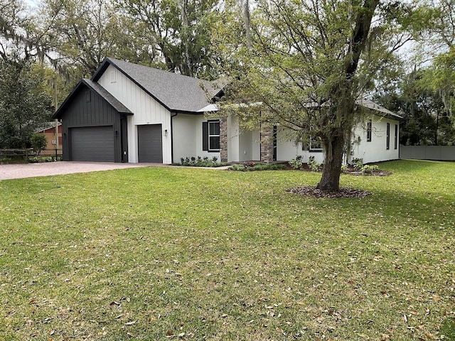 modern farmhouse with board and batten siding, a front lawn, fence, driveway, and an attached garage