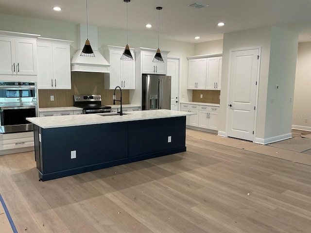 kitchen featuring white cabinetry, light countertops, light wood-type flooring, and appliances with stainless steel finishes