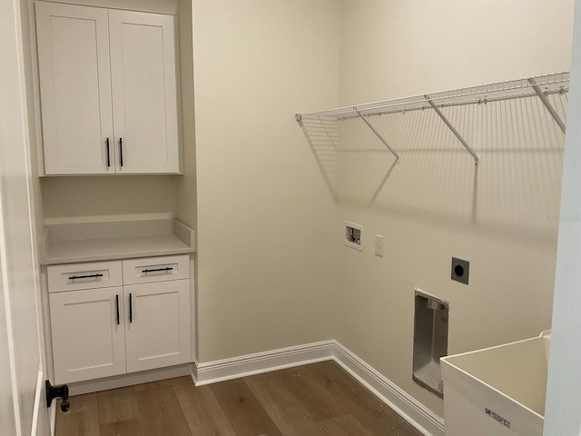 laundry area featuring baseboards, dark wood finished floors, washer hookup, cabinet space, and hookup for an electric dryer