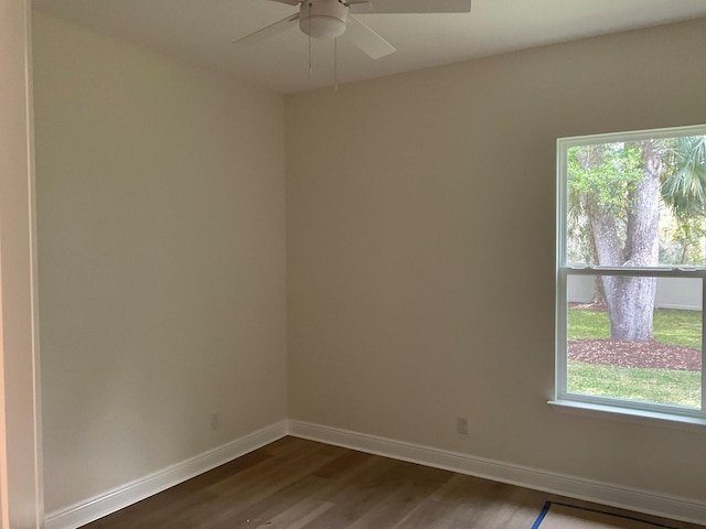 empty room with a ceiling fan, baseboards, and dark wood-style flooring