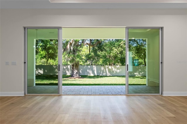 doorway to outside with wood finished floors and baseboards