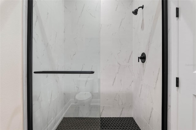 full bathroom featuring toilet and a marble finish shower