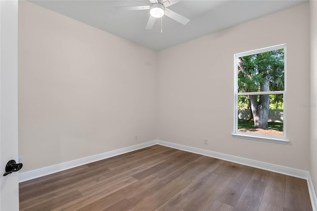 spare room with baseboards, a ceiling fan, and wood finished floors