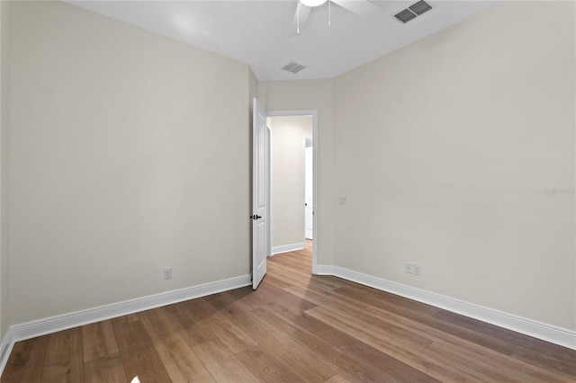 unfurnished room featuring wood finished floors, baseboards, a ceiling fan, and visible vents
