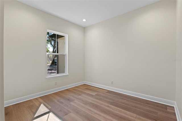 unfurnished room with baseboards, recessed lighting, and wood finished floors