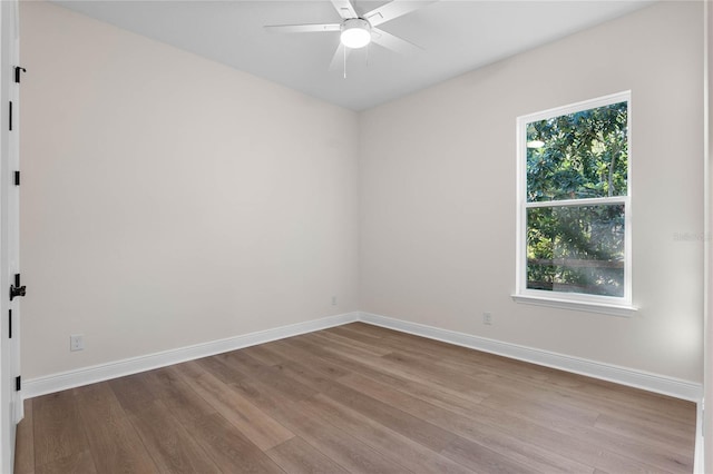 spare room featuring baseboards, ceiling fan, and wood finished floors