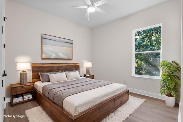 bedroom with ceiling fan, baseboards, and wood finished floors