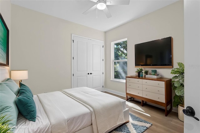 bedroom with light wood-style floors, baseboards, and a ceiling fan