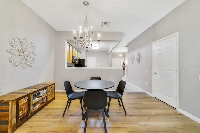 dining room with a notable chandelier and light hardwood / wood-style flooring