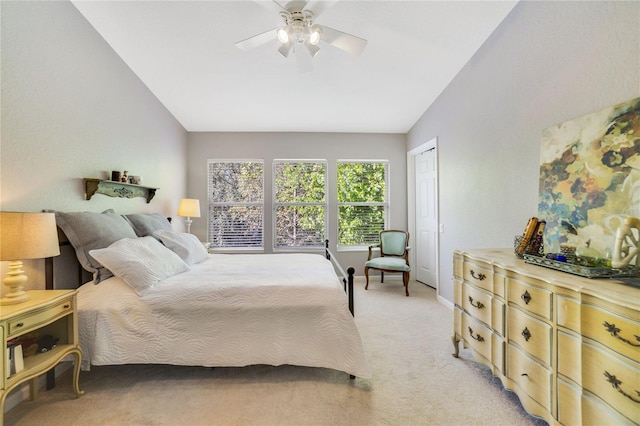 bedroom with ceiling fan, a closet, light colored carpet, and vaulted ceiling