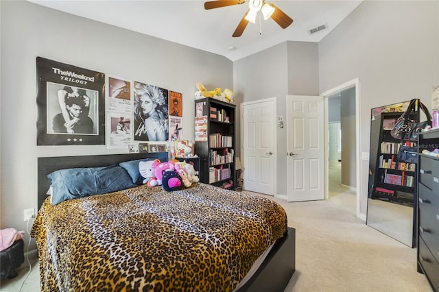 carpeted bedroom with ceiling fan and a high ceiling