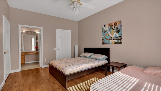 bedroom with ensuite bath, ceiling fan, and light hardwood / wood-style flooring