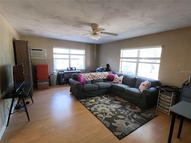 living room featuring ceiling fan, light hardwood / wood-style floors, and an AC wall unit