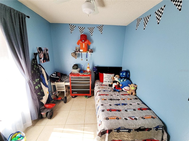 tiled bedroom with ceiling fan and a textured ceiling