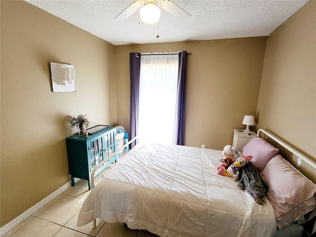 tiled bedroom with ceiling fan and a textured ceiling