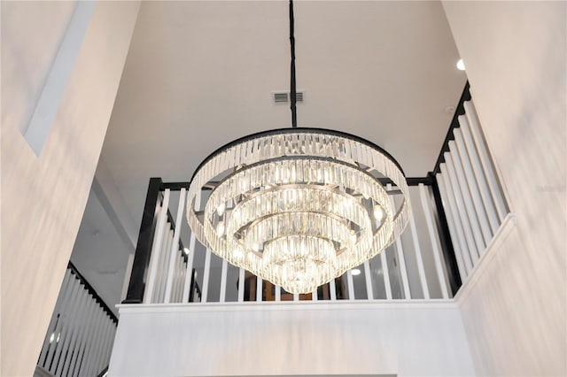 stairway featuring a towering ceiling and a chandelier