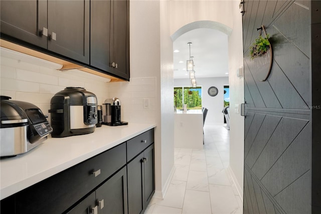 interior space with backsplash and pendant lighting