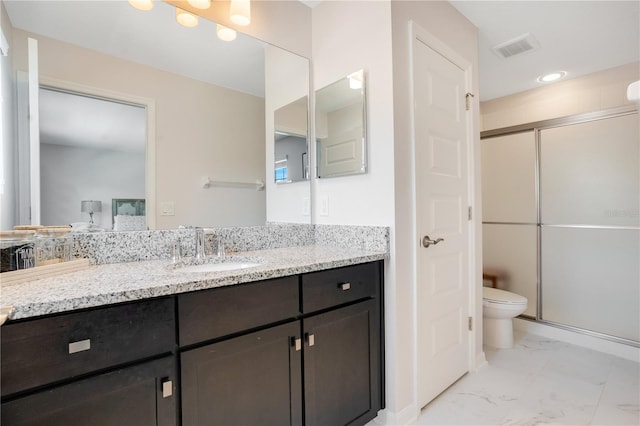 bathroom with toilet, an enclosed shower, and vanity