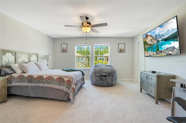 carpeted bedroom with ceiling fan and a textured ceiling