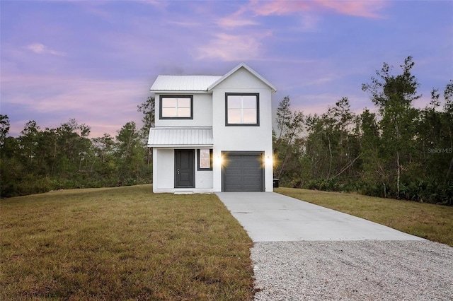 view of front of property featuring a garage and a lawn