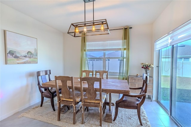 dining area with light tile patterned floors, a wealth of natural light, and a notable chandelier