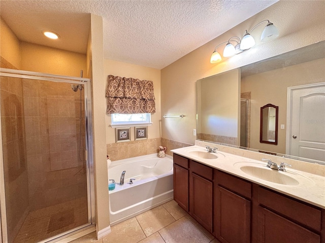 bathroom featuring tile patterned floors, vanity, independent shower and bath, and a textured ceiling