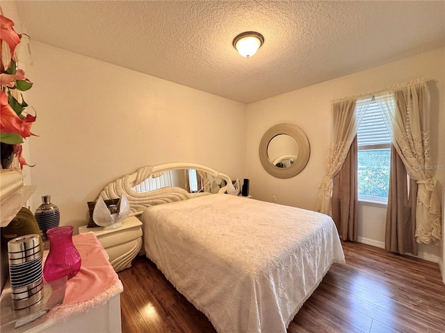 bedroom featuring dark hardwood / wood-style floors and a textured ceiling