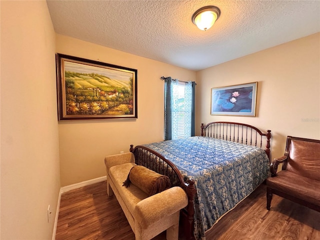 bedroom featuring dark wood-type flooring and a textured ceiling