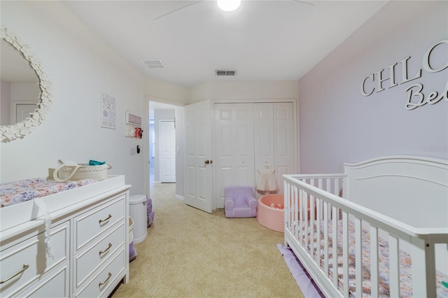 carpeted bedroom featuring a closet, a nursery area, and ceiling fan