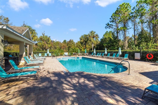 view of swimming pool featuring ceiling fan and a patio