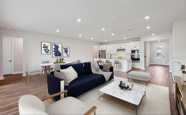 living room with light hardwood / wood-style floors and sink