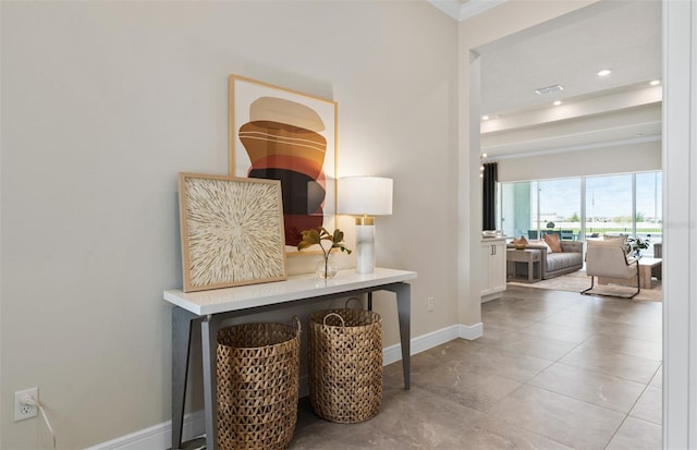 hall featuring light tile patterned floors and ornamental molding