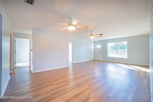 empty room with ceiling fan, light wood-type flooring, and a textured ceiling