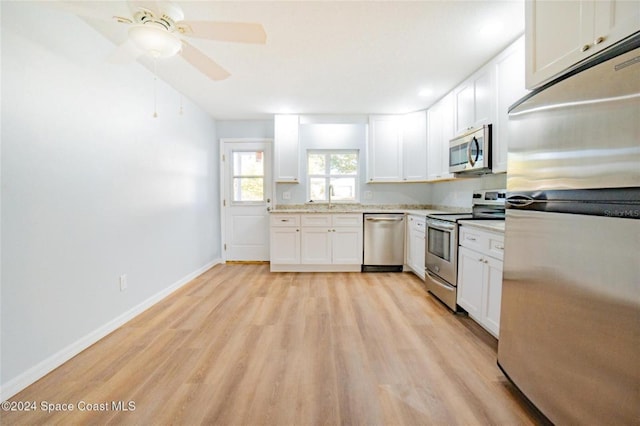 kitchen with stainless steel appliances, white cabinetry, light hardwood / wood-style floors, and sink