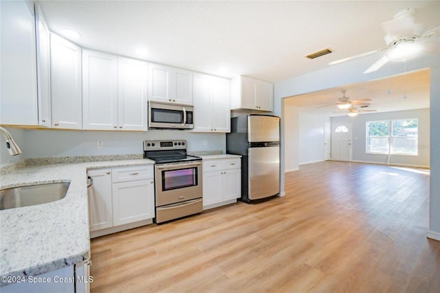 kitchen with appliances with stainless steel finishes, light hardwood / wood-style flooring, white cabinetry, and sink