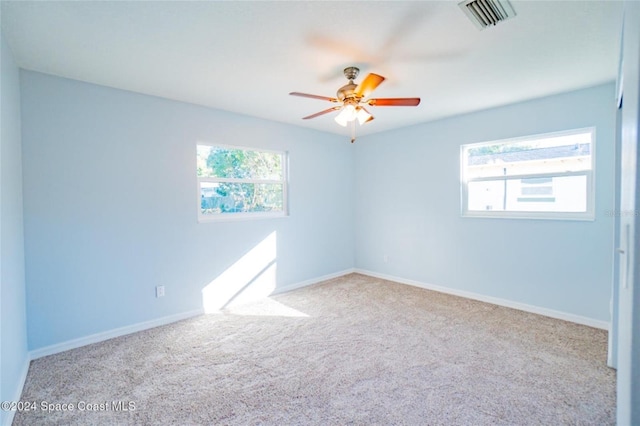 carpeted spare room with ceiling fan