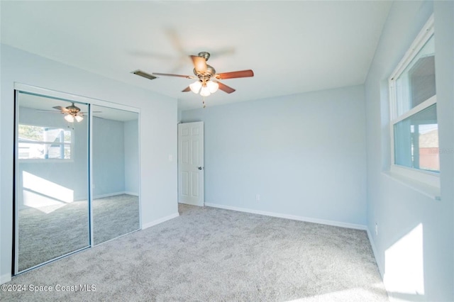 unfurnished bedroom with ceiling fan, light colored carpet, and a closet