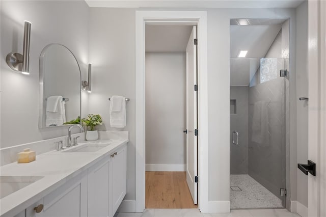 bathroom with tile patterned flooring, vanity, and walk in shower