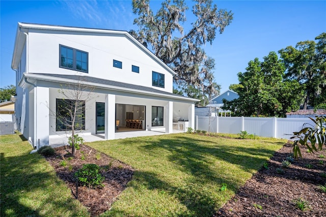 rear view of house featuring a patio area and a yard