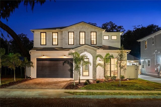 view of front of home with a garage and a lawn