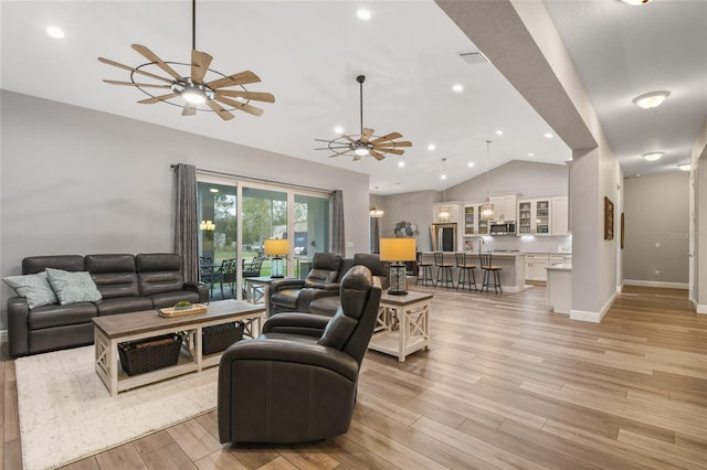 living room featuring light wood-type flooring and vaulted ceiling