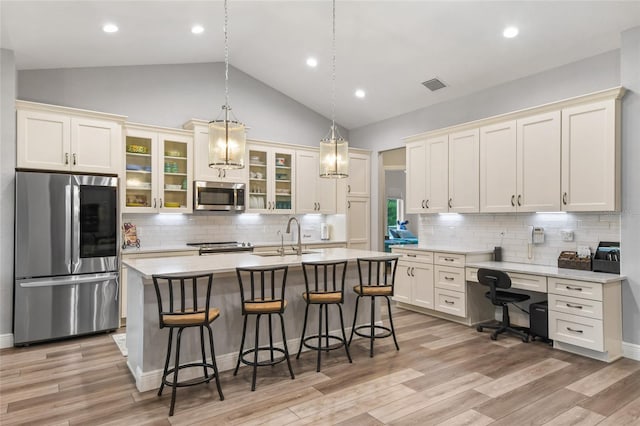 kitchen with appliances with stainless steel finishes, tasteful backsplash, lofted ceiling, and sink