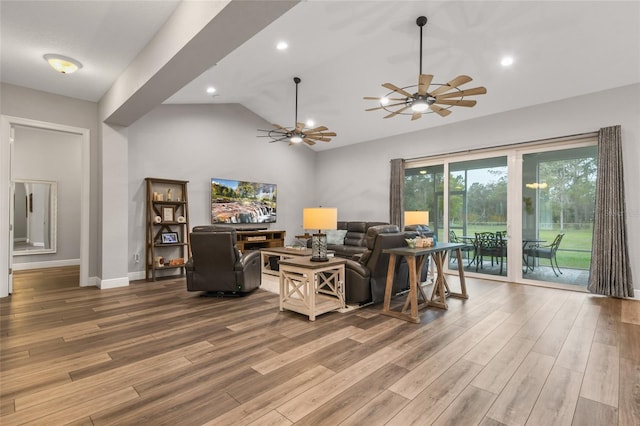 living room with ceiling fan, wood-type flooring, and vaulted ceiling