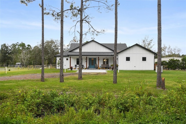 rear view of house featuring a porch and a lawn