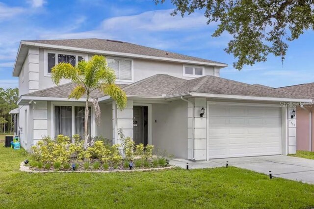 view of front of house with cooling unit, a garage, and a front yard