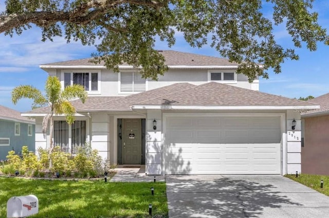 view of property with a front lawn and a garage