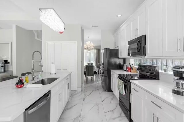 2912 Sunset Lakes Blvd, Kissimmee, FL 34747 - kitchen featuring black appliances, a sink, a chandelier, white cabinets, and hanging light fixtures